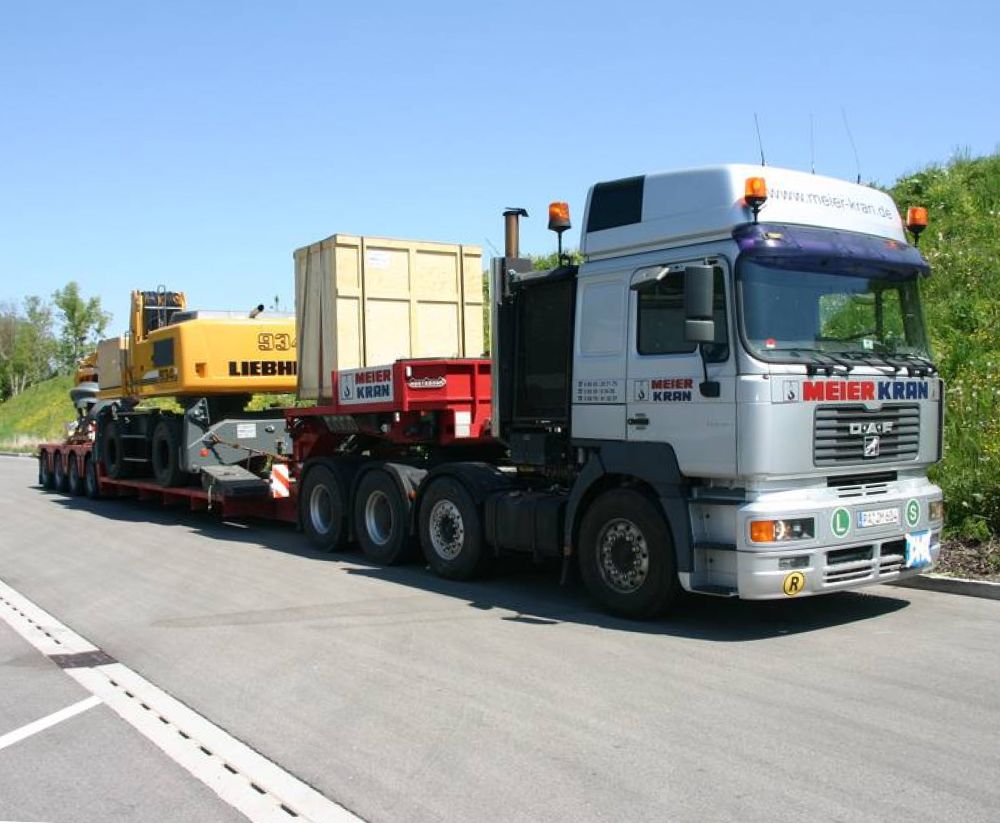 Transport von Baumaschine mit Tieflader und 3-Achs-Sattelzug